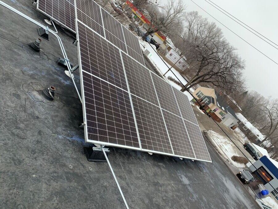 Solar panels installed on a flat roof in Madison, WI, during winter