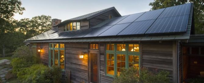 Rustic home with rooftop solar panels surrounded by greenery, illustrating eco-friendly living and solar energy use.