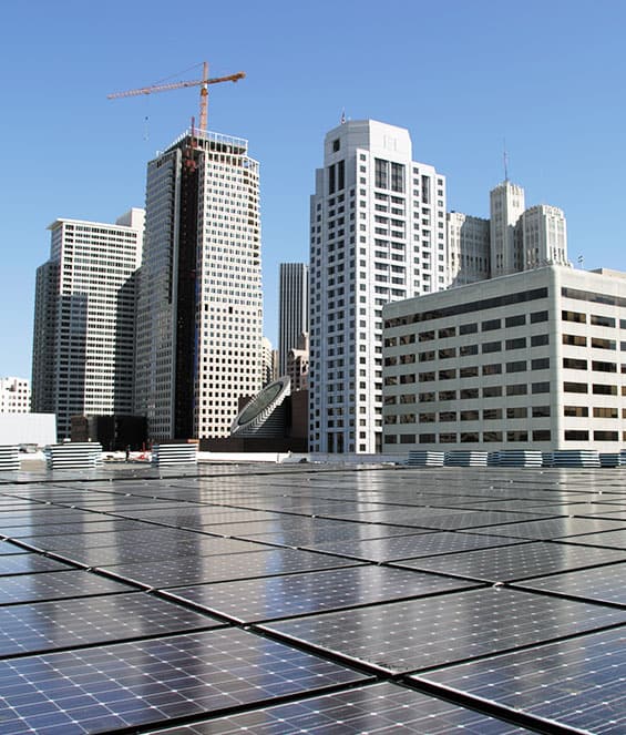 Rooftop solar panels on a commercial building in a cityscape, highlighting urban solar energy solutions.