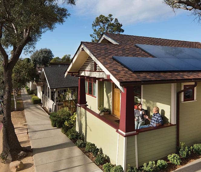 Residential home with rooftop solar panels installed by Wolf River Electric, featuring a couple sitting on the porch.