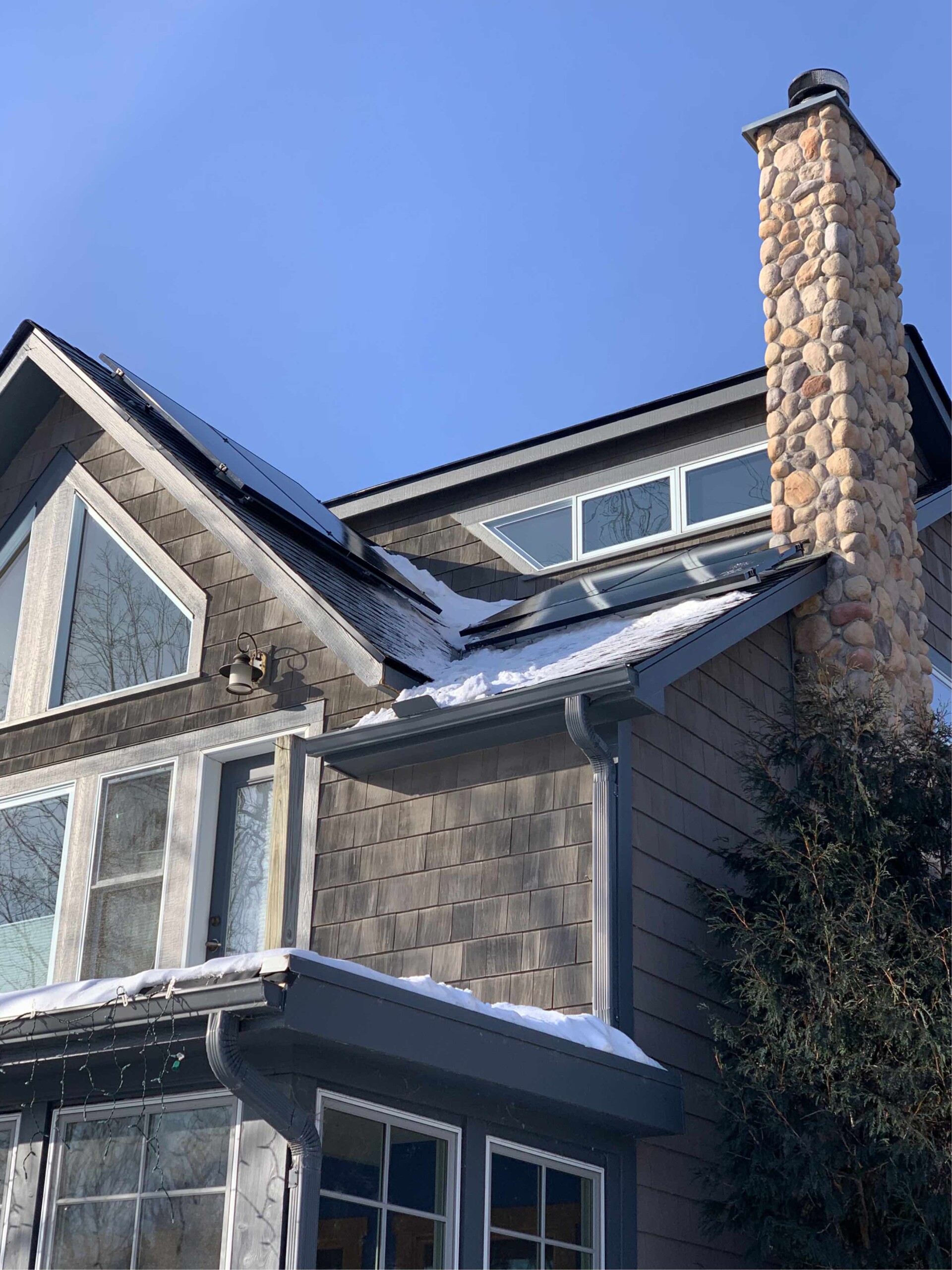 Solar panels installed on a residential roof in winter by Wolf River Electric, showcasing energy efficiency in cold climates.