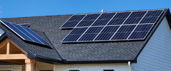 Residential rooftop solar panels installed by Wolf River Electric on a modern home, showcasing sustainable energy solutions under a clear blue sky.