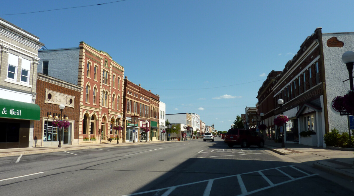 A business lined street in New Ulm, Minnesota showing a clear blue sky during the day.
