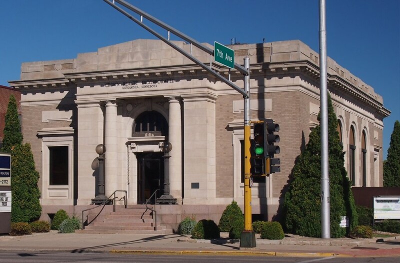 Front shot of the Alexandria Post Office with a street sign for 7th Ave in the forefront during the day. Front shot of the Alexandria Post Office with a street sign for 7th Ave in the forefront during the day.