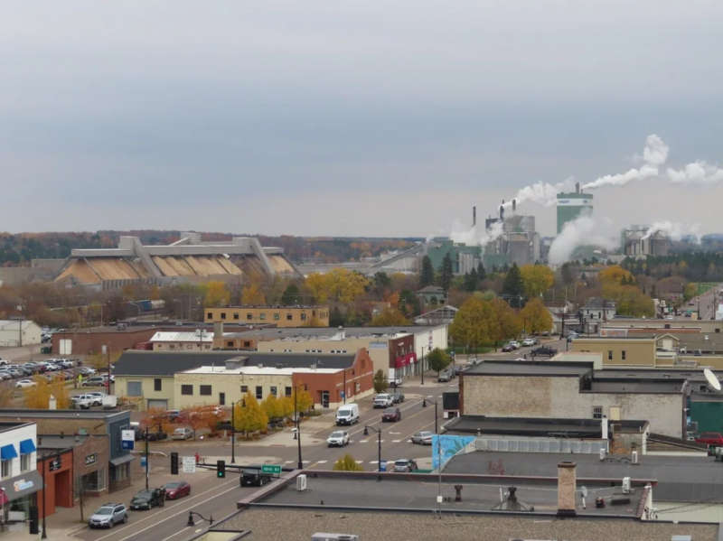 Aerial shot of businesses and billowing smoke stacks in Cloquet, Minnesota during autumn.