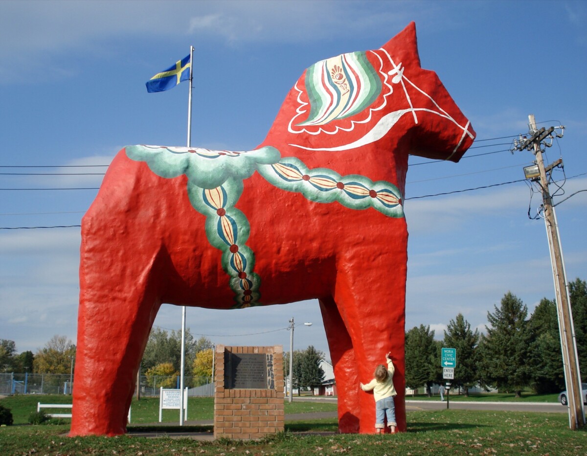 Dala_horse-Mora,_Minnesota-20070929 Side shot of a large statue of a Swedish Dala Horse with a Swedish flag in the background in Mora, Minnesota.