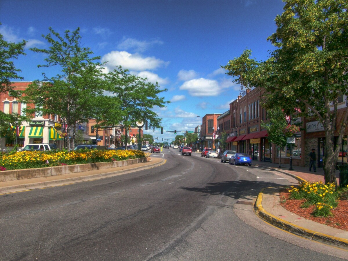 View of a tree lined street in downtown Anoka in Minnesota during the day.