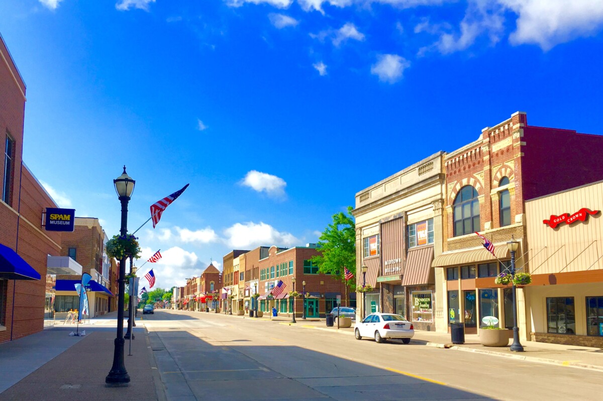 Businesses along a street in downtown Austin, Minnesota looking south with a blue sky in the background.