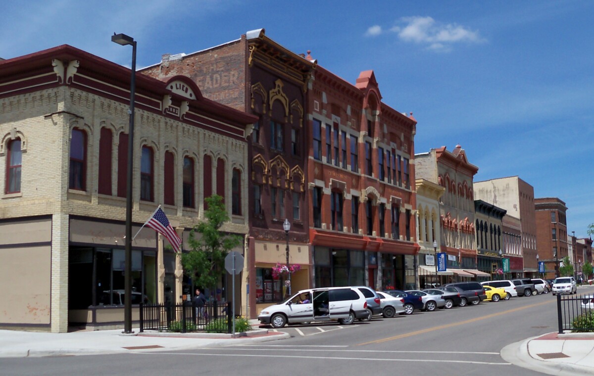 Buildings and cars parked on a street in Faribault, Minnesota during the day. Buildings and cars parked on a street in Faribault, Minnesota during the day.
