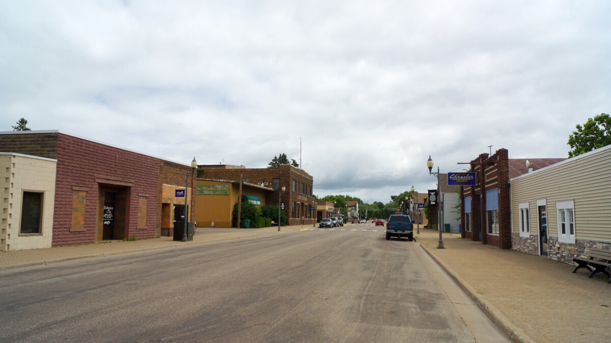 A street with businesses on each side on an overcast day in Isanti, Minnesota.