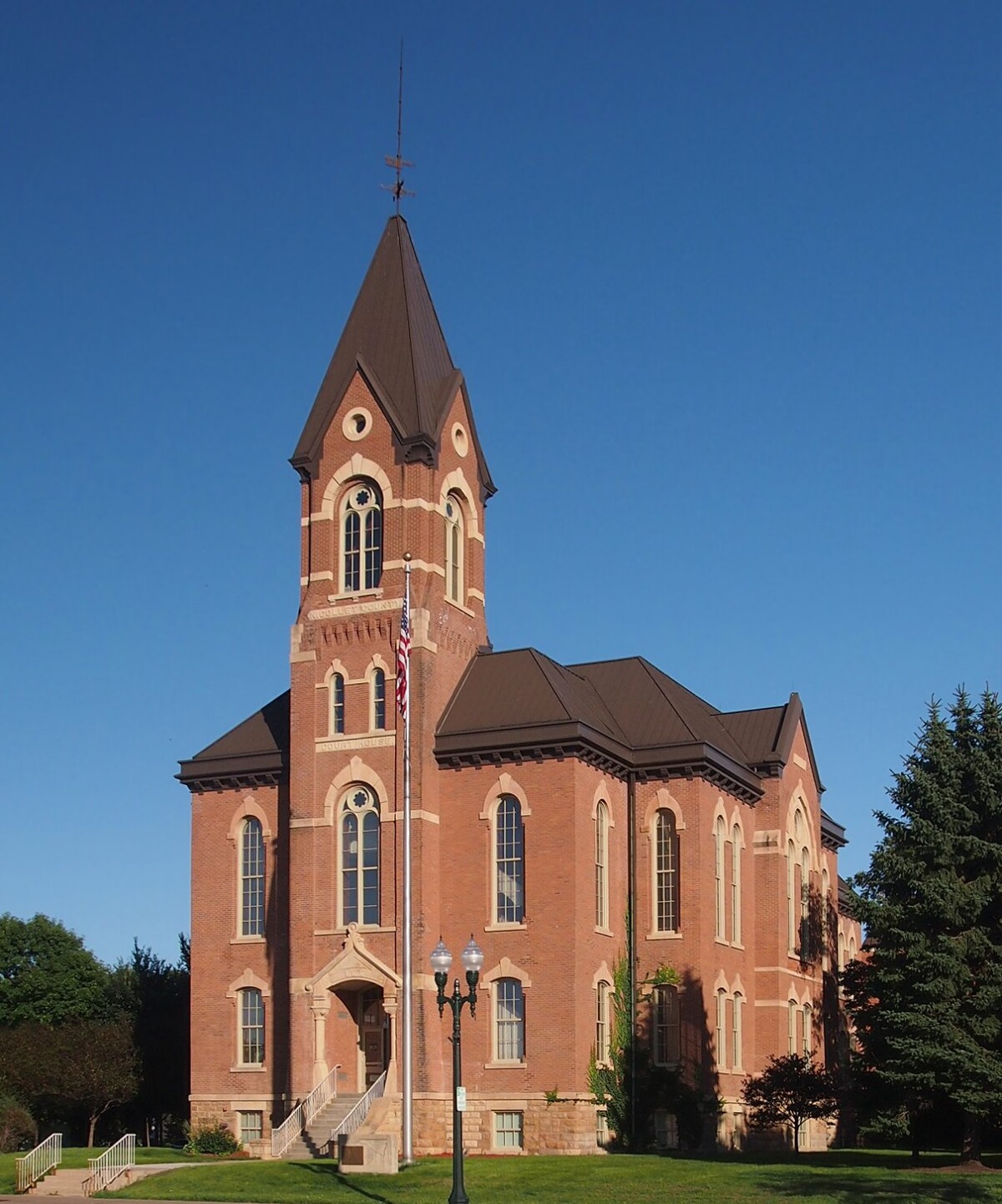 A front shot of the Nicollet County Courthouse with green trees on both sides against a clear blue sky.