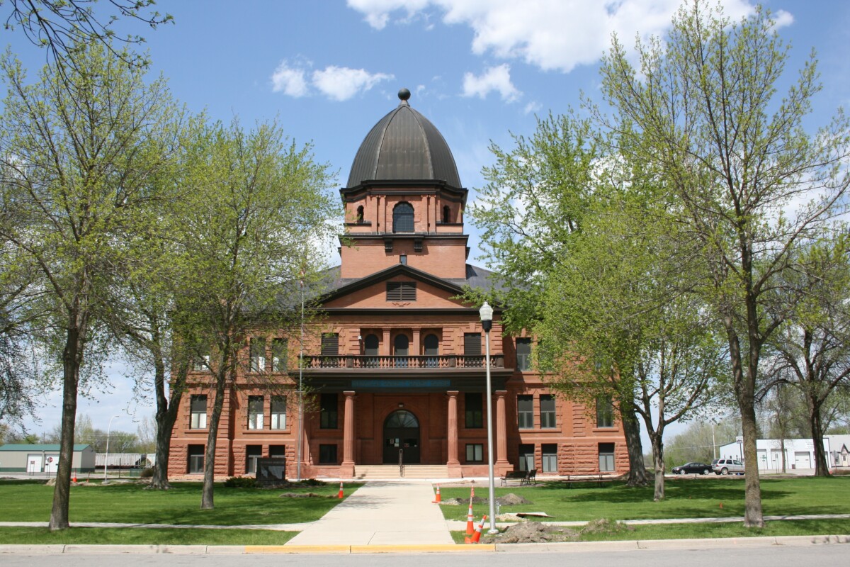 Front shot of the Renville County Courthouse with trees on each side during the day. Front shot of the Renville County Courthouse with trees on each side during the day.