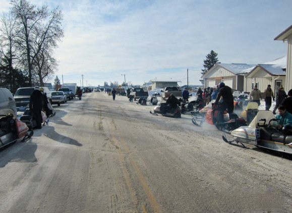 Snowmobile gathering along main street in Tamarack, Minnesota during winter community event Snowmobile gathering along main street in Tamarack, Minnesota during winter community event