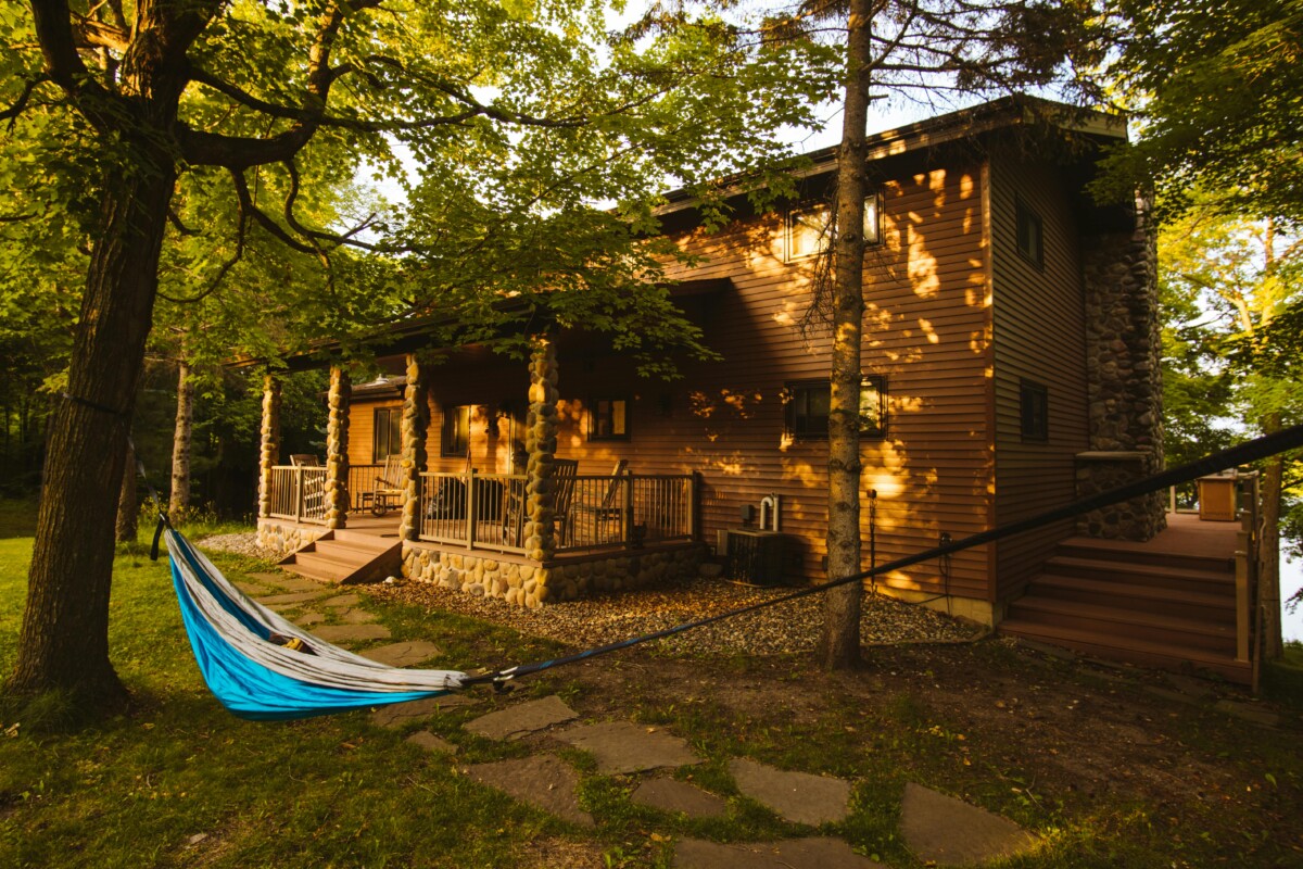 Rustic cabin with hammock in wooded backyard in Andover, Minnesota, ideal for peaceful retreats and nature getaways