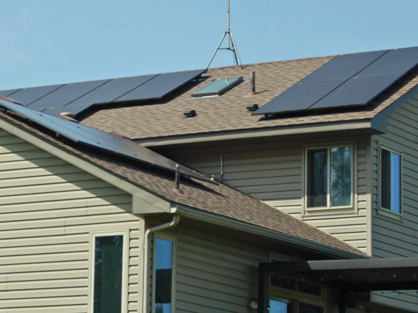 Side view of residential solar panels installed on a tan home with pitched roof by Wolf River Electric