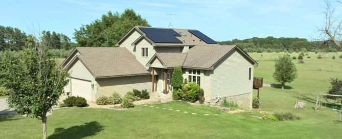 Full front exterior of a rural Minnesota home with rooftop solar panels installed by Wolf River Electric