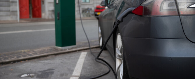 Electric vehicle connected to a public EV charging station, highlighting EV charging infrastructure and clean energy solutions.