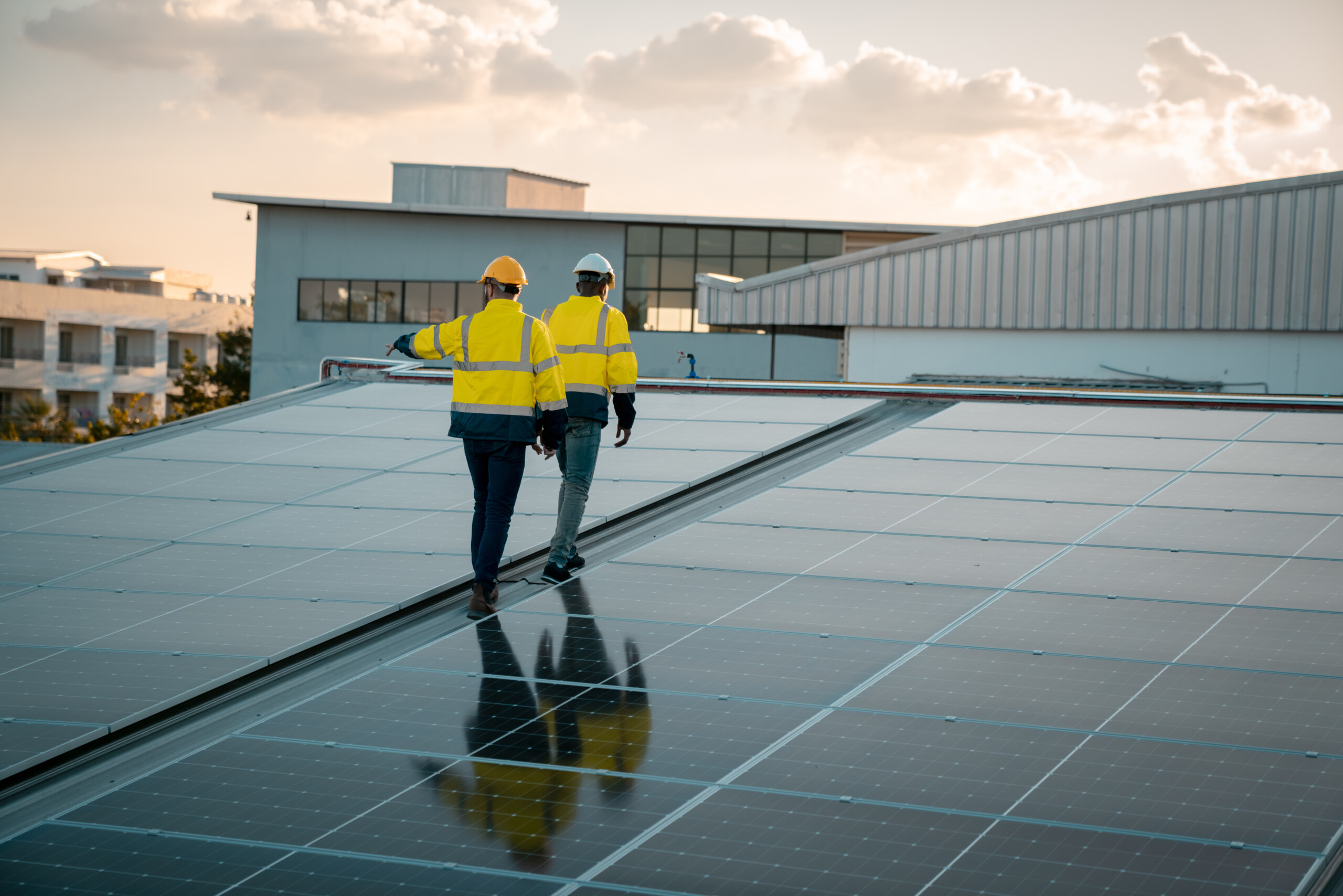 Wolf River Electric solar professionals inspecting commercial rooftop solar panels to help Midwest businesses reduce electricity costs through solar net metering.
