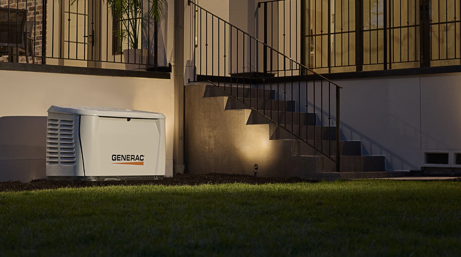 Generac standby generator beside home at dusk