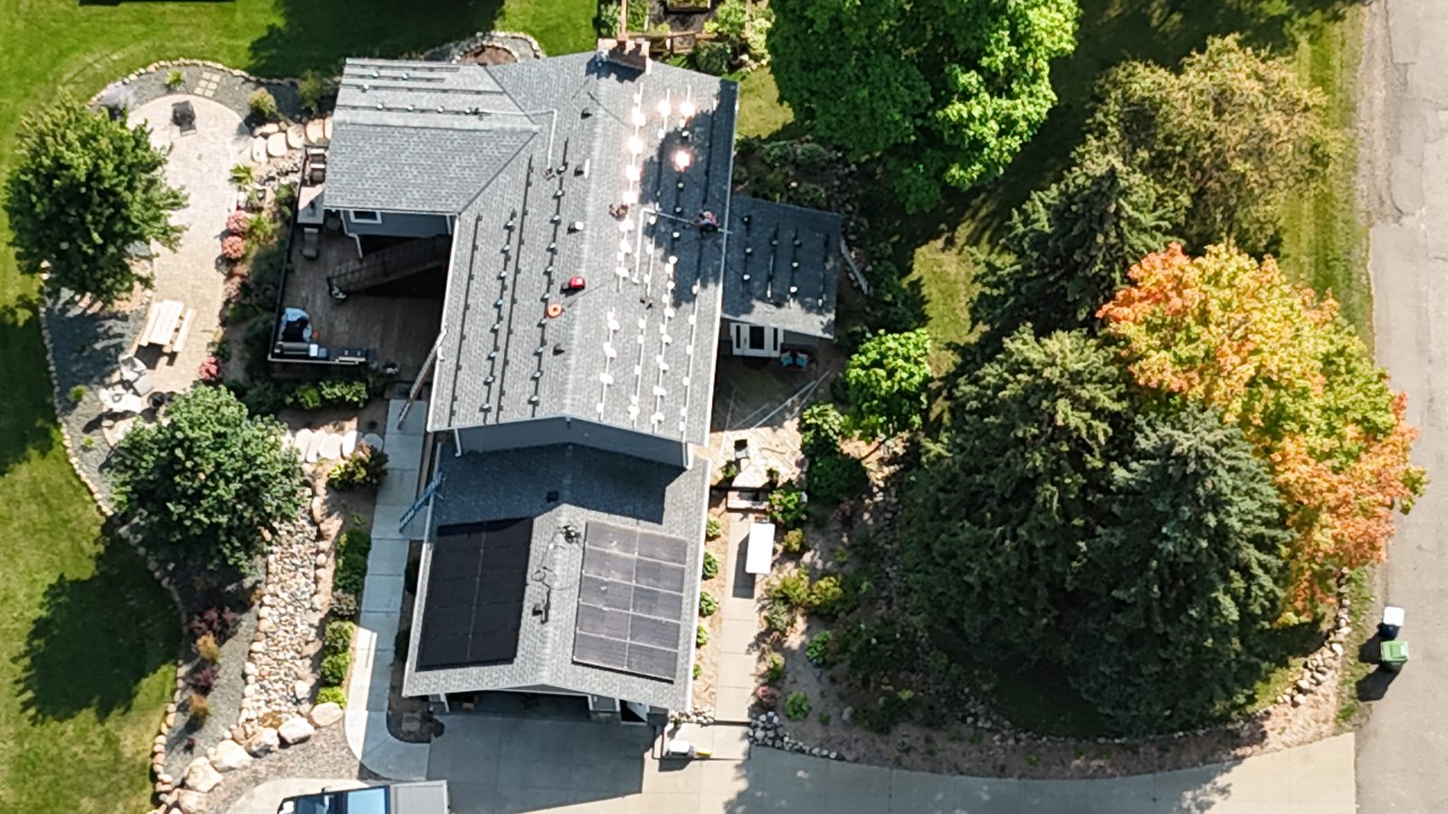 Aerial view of home with rooftop solar on wooded lot, installed by Wolf River Electric