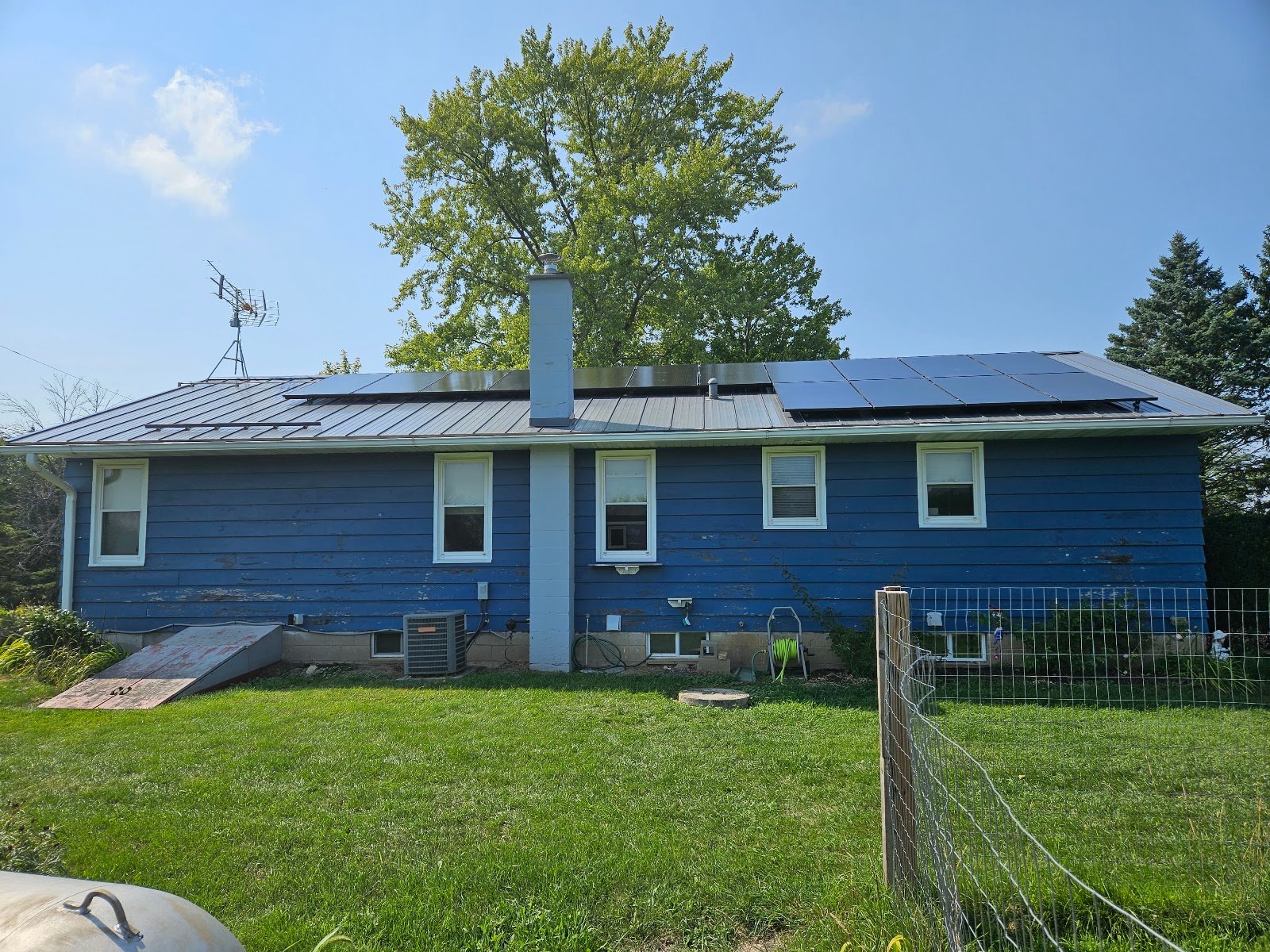 Blue home with solar panels, installed by Wolf River Electric