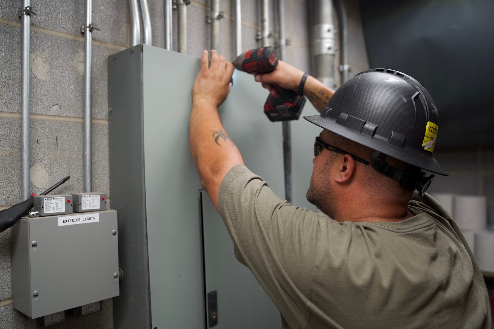 Wolf River Electric electrician hard hat at panelboard