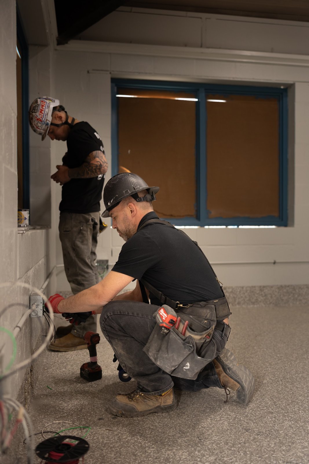 Wolf River Electric electrician hard hat crouching
