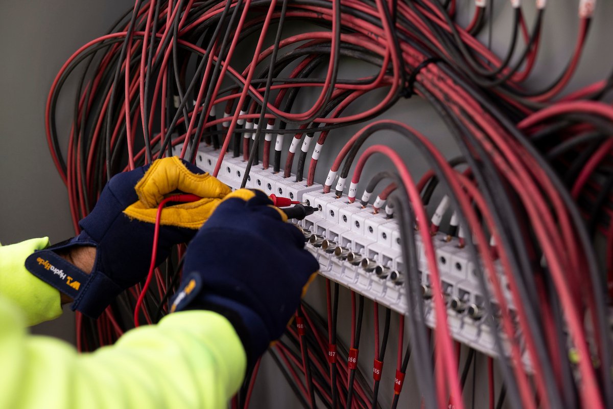 Wolf River Electric electrician testing a terminal block