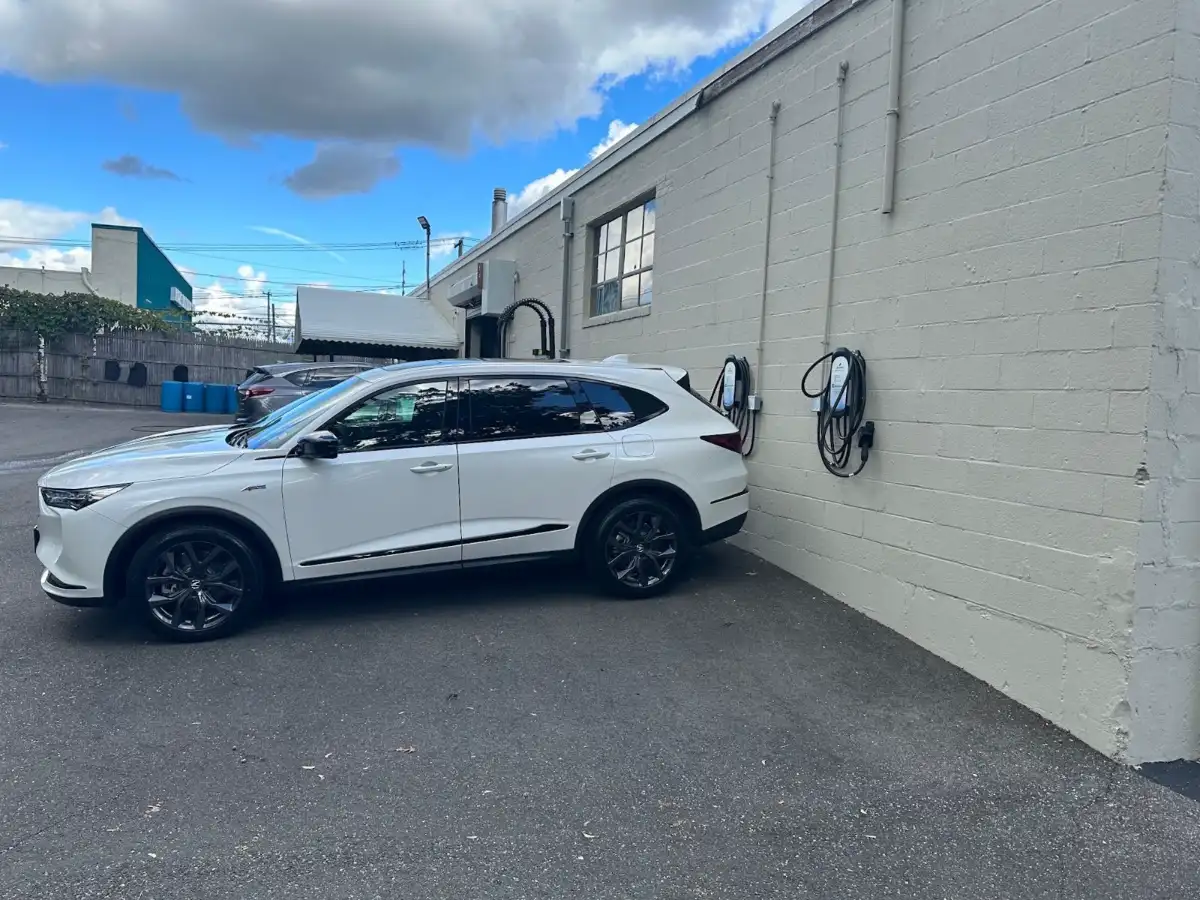 Level 2 EV chargers on a building wall at a commercial parking lot, installed by Wolf River Electric