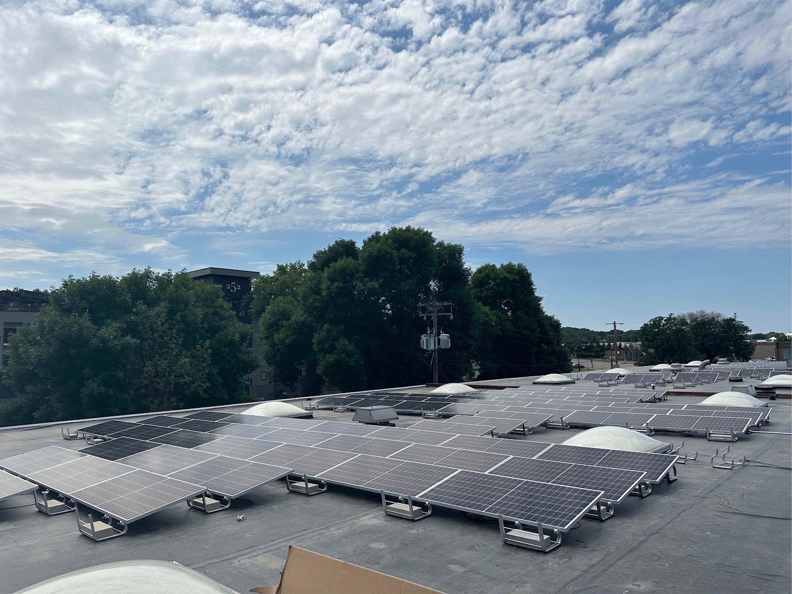 Flat roof solar array wide sky, installed by Wolf River Electric