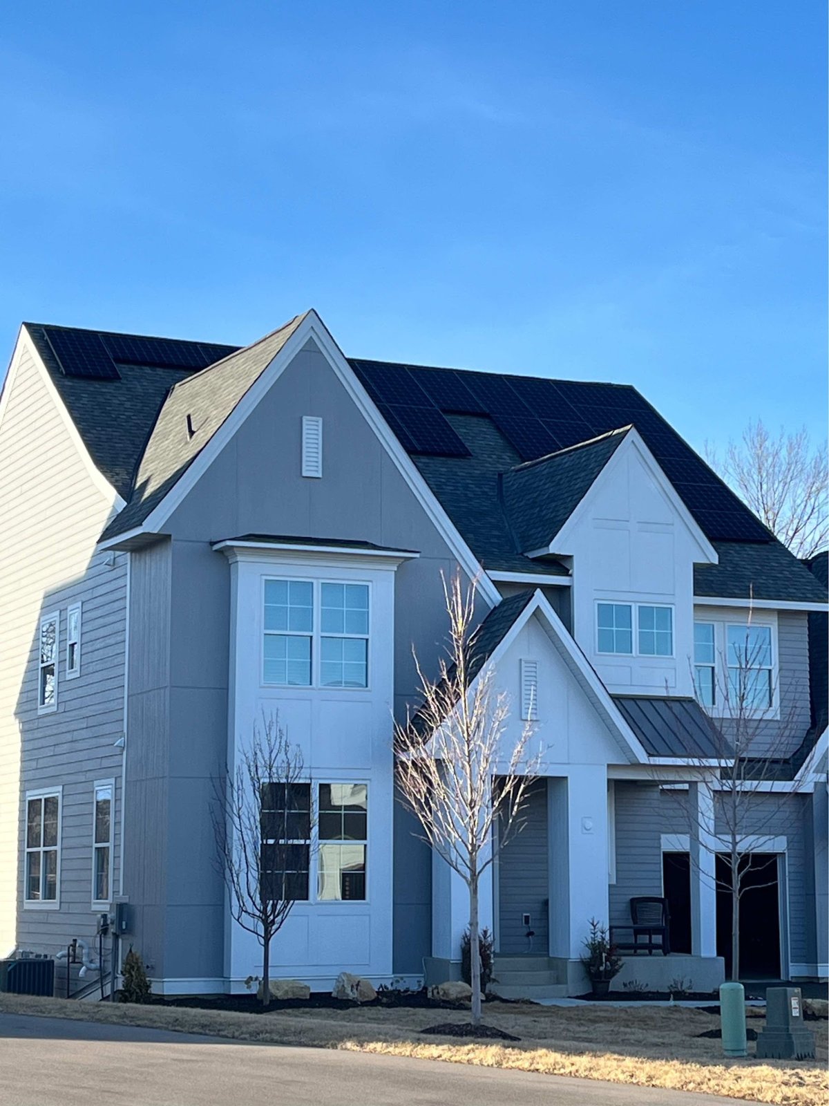 Gray two story home with solar panels, installed by Wolf River Electric