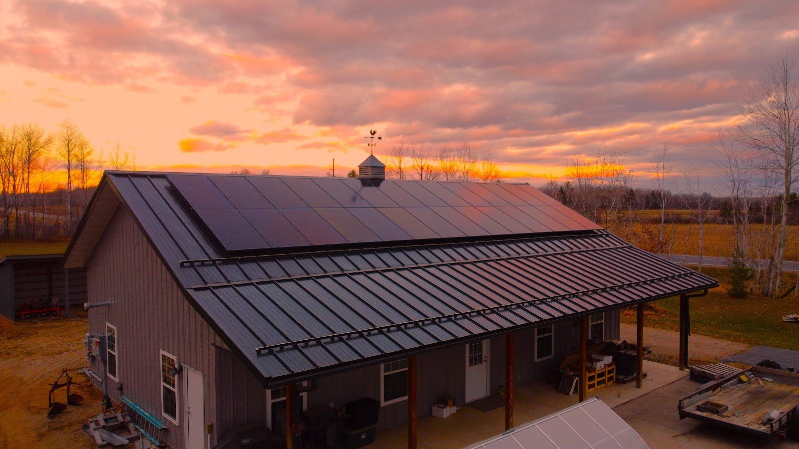 Solar panels on a metal roof at sunset, installed by Wolf River Electric