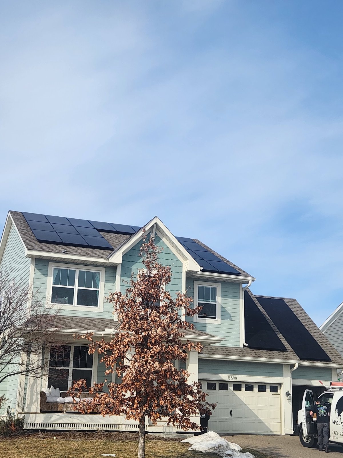 Home with solar panels blue siding, installed by Wolf River Electric