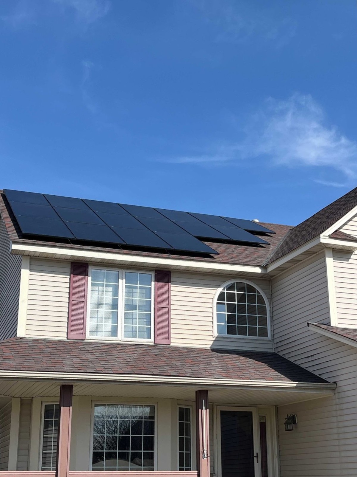 Home with solar panels blue sky, installed by Wolf River Electric