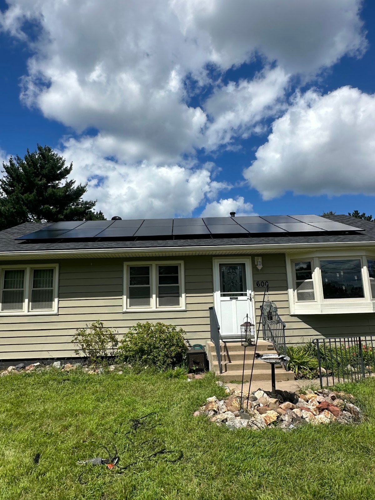 Home with solar panels green siding, installed by Wolf River Electric