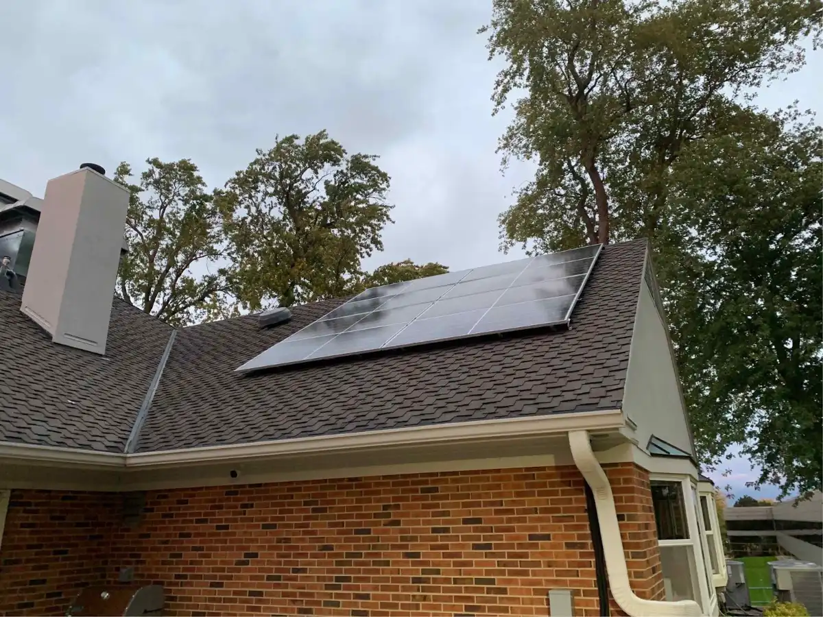 Two-story home with rooftop solar panels among trees, installed by Wolf River Electric