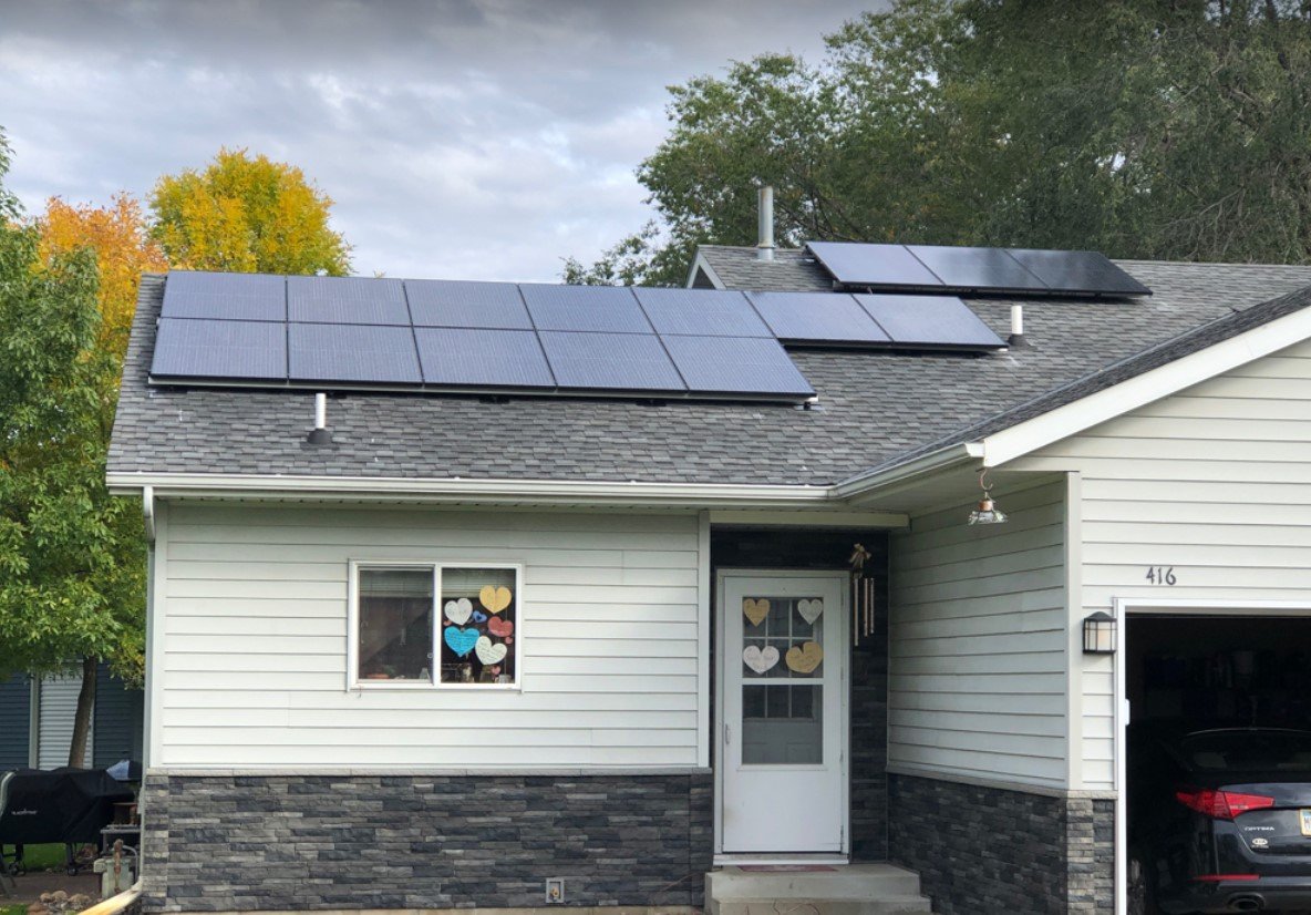 Home with solar panels white siding, installed by Wolf River Electric