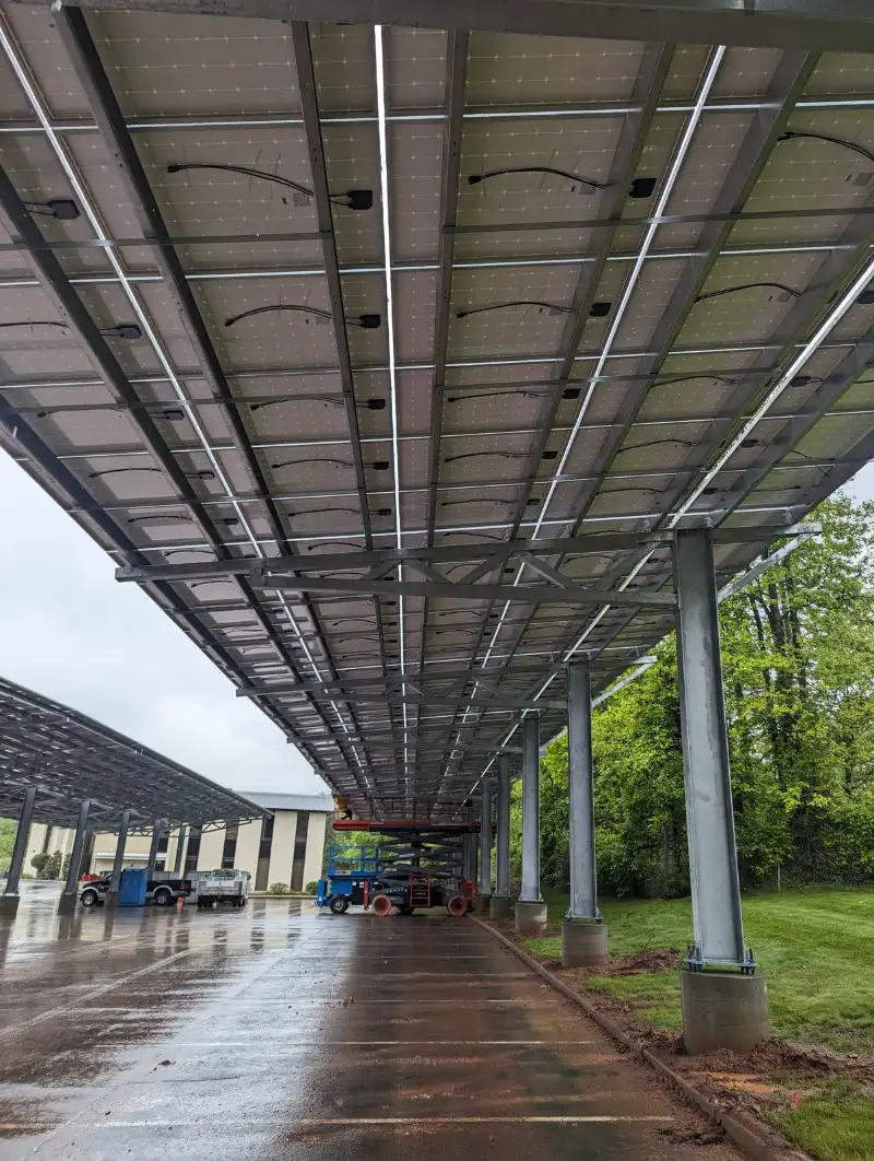 Rows of solar carport canopies over a parking lot, installed by Wolf River Electric