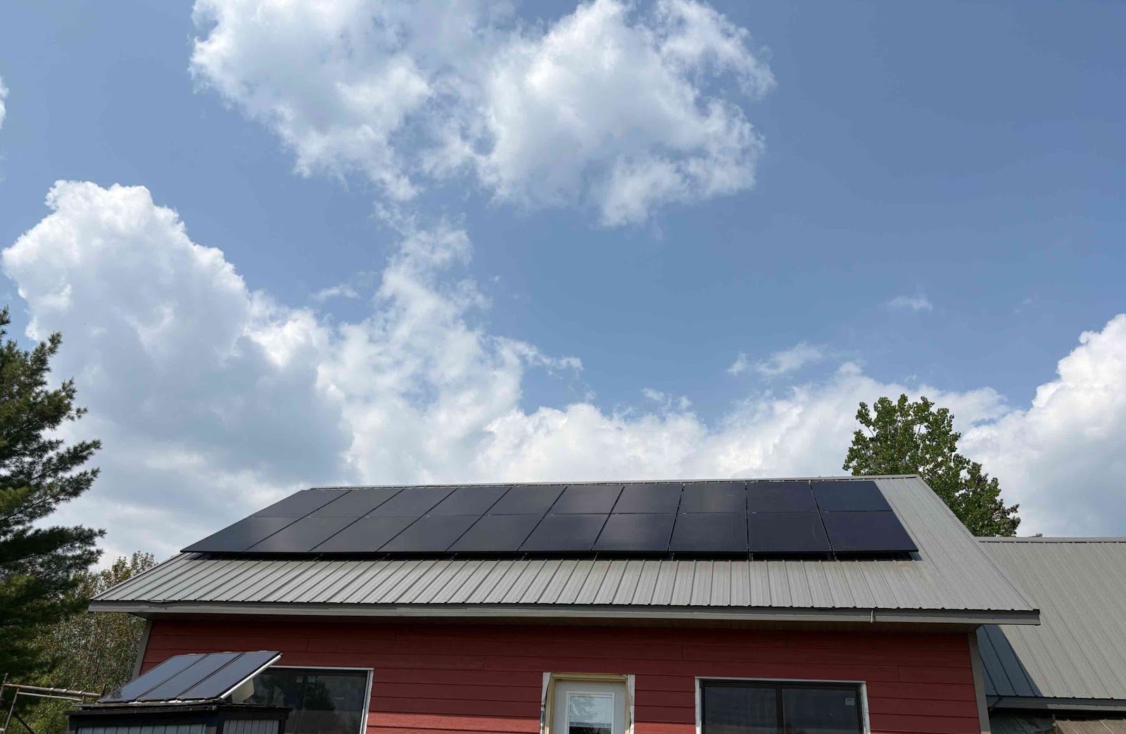 Red home with solar panels, installed by Wolf River Electric