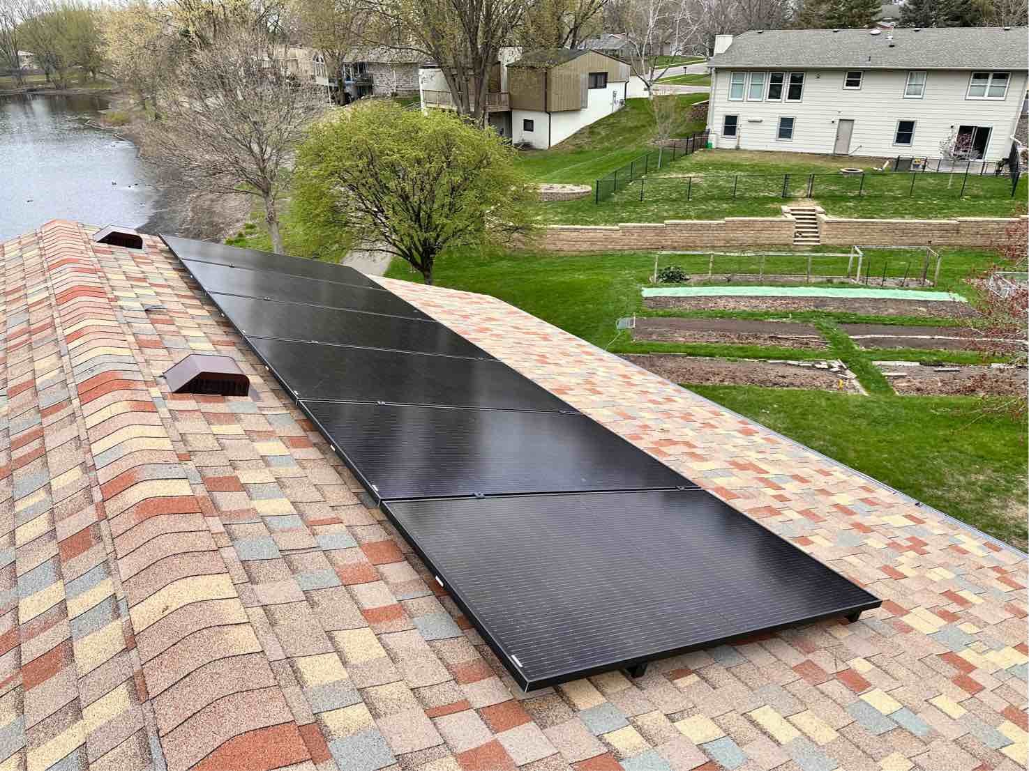 Roof solar panels pond view, installed by Wolf River Electric