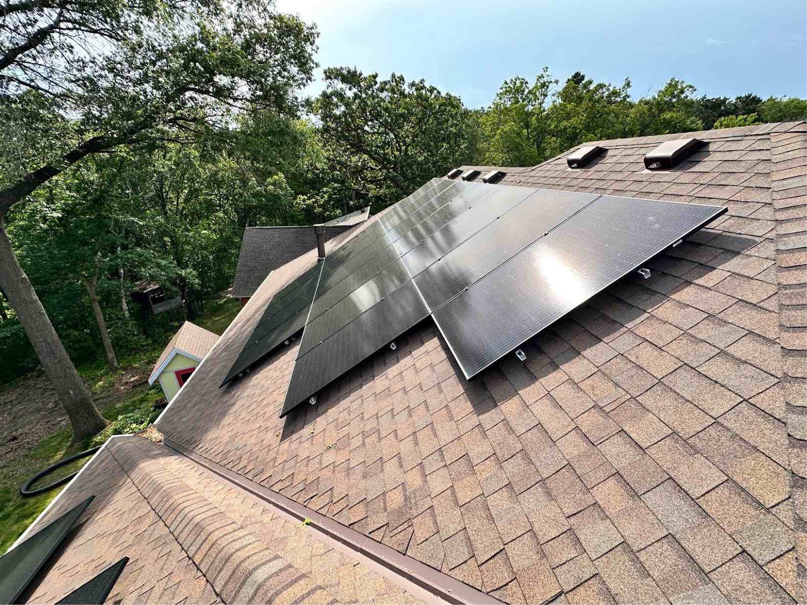 Roof solar panels tree line, installed by Wolf River Electric