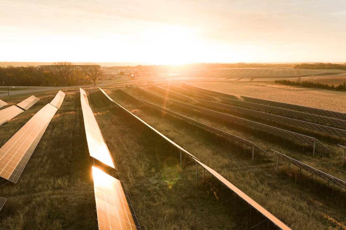 Sunrise over solar farm rows, installed by Wolf River Electric