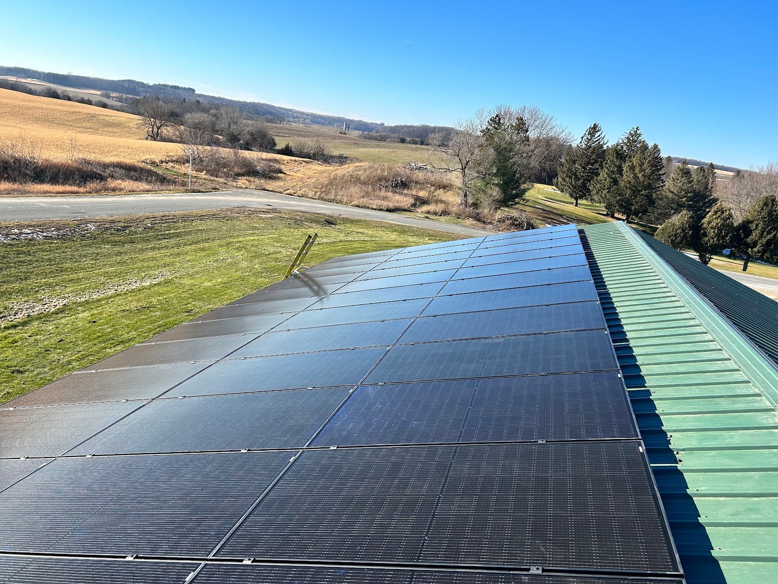 Solar panels green metal roof valley view, installed by Wolf River Electric