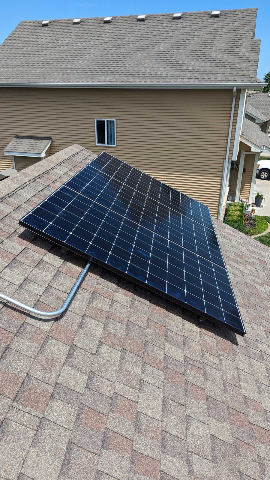 Solar panels on tan shingles, installed by Wolf River Electric