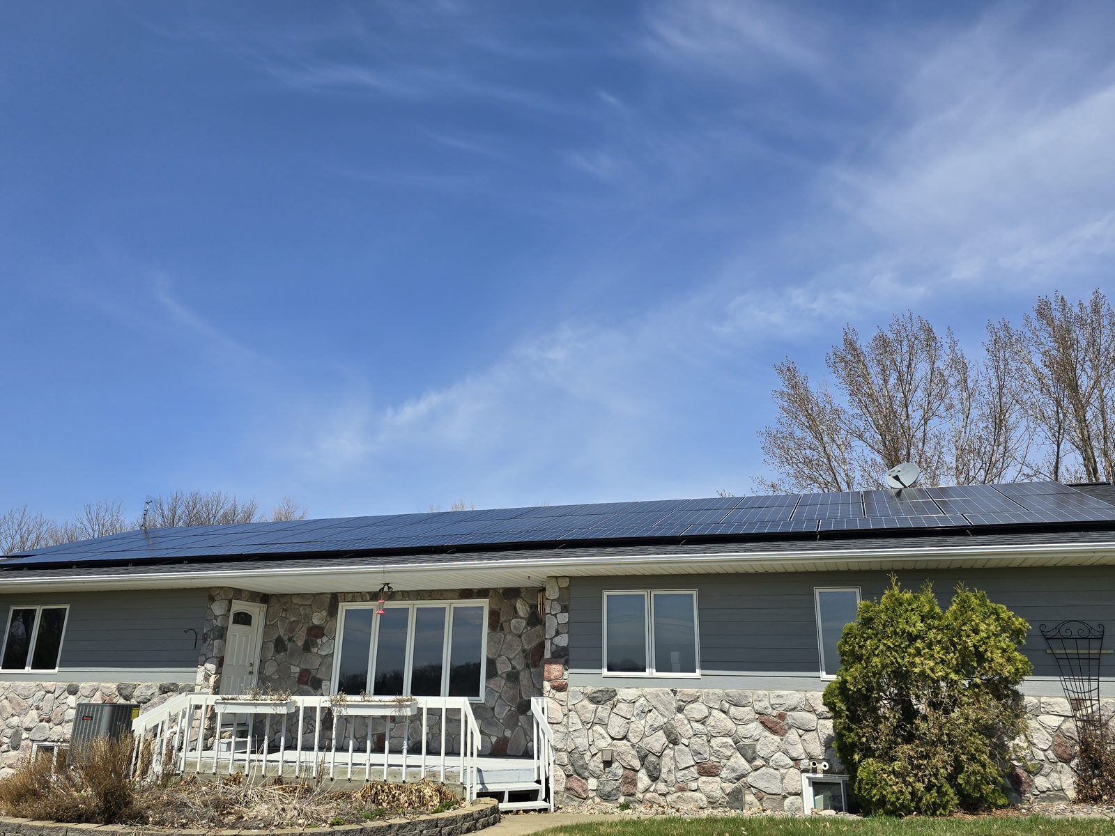 Stone front rambler with solar, installed by Wolf River Electric
