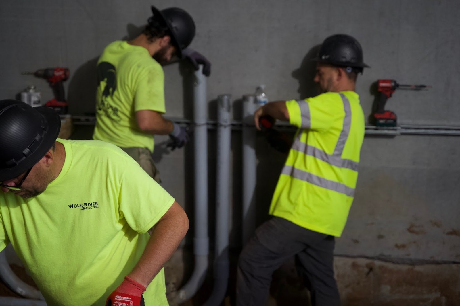 Wolf River Electric two electricians hard hat checking conduit